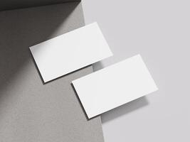 Business card resting on a light taupe cement block, offering a neutral and elegant presentation for design portfolios. photo