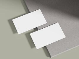 A business card mockup leaning on a muted grey cement block with soft lighting, ideal for luxury brand displays. photo