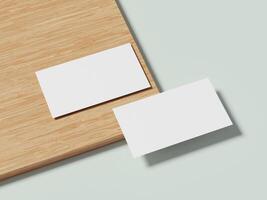 A pair of white business cards lying on a wooden table, with a subtle shadow highlighting their minimalist design. photo