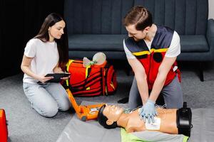 Instructor demonstrating cpr chest compression on a dummy in class photo