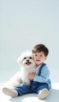 A little boy sitting on the floor with a white dog photo