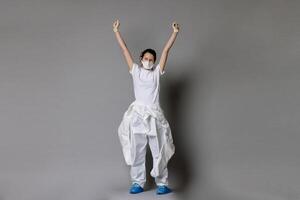 Frontliner in happy mood in hazmat suit. Covid-19 situation with grey clean background and copyspace. photo