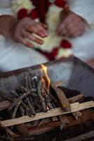 During an Indian wedding, a priest performs a ritual with fire and wood photo