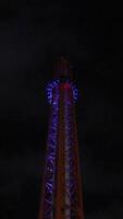 Tower, Night, Illumination. Red amusement park ride illuminated at night, showcasing its structure and height. video