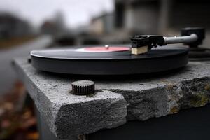 Vintage vinyl record player on stone surface outdoors during a foggy morning photo