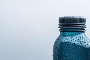 Close-up of a water bottle reflecting droplets against a gray background at morning light photo