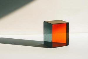 Colorful glass cube casting a shadow on a reflective surface in natural light photo