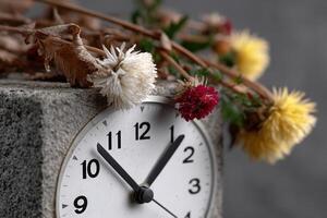 Flowers and clock display the passage of time in a serene indoor setting photo