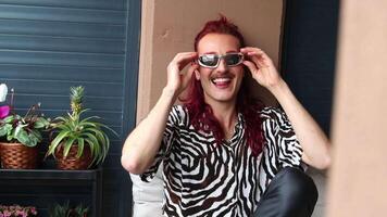 Non-binary influencer laughing and having fun on a balcony video