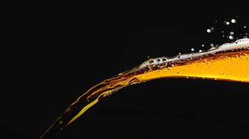 Beer pouring from a bottle against a black background creating bubbles and splashes photo
