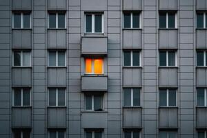 iluminado ventana contrastes en contra gris edificio fachada durante noche crepúsculo foto