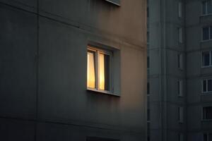 Evening sunlight illuminates a window in an urban building during twilight hours photo