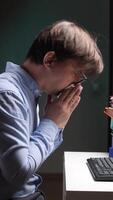 vertical close-up Office worker blowing nose while working late at night video