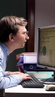vertical close-up Office worker with bad posture typing on keyboard and looking at screen video
