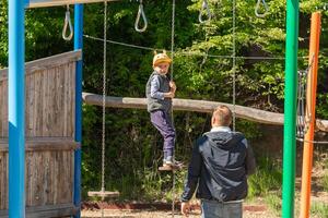 Child Enjoying Playground Adventure with Parental Support photo