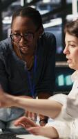 Vertical Data center technicians adjusting blade server hardware powering artificial intelligence processing operations. Coworkers oversee server arrays handling training datasets infrastructure, camera A video