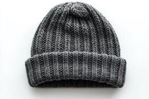 Knitted gray beanie hat resting on white background with clear details and texture photo