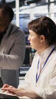 Vertical Joyous data center team leader giving high five to worker after successful infrastructure upgrade. Pleased coworkers celebrating collaborative achievement during AI systems deployment, camera A video