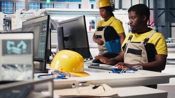 PC based solar technician reviews automation data in production factory, manufacturing industry focused on renewable energy. Worker tracks solar panels and machine performance. Camera B. video