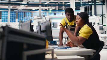 Team of black engineers finetuning the manufacturing on solar panels at the factory, doing quality control for the production line. Experts working on alternative energy industry. Camera A. video