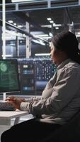 Vertical Scared data center technicians reacting to virus warning on PC display, scrambling to launch emergency response protocol. Admins run around server room, urgently trying to fix hacked systems, camera A video