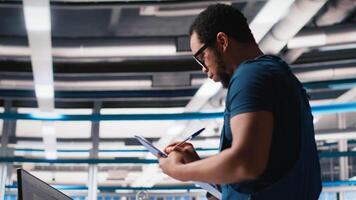 Supervisor in solar panel factory investigating potential malfunctioning systems, reading paperwork and user manuals. Inspector ensuring seamless production, reducing downtime. Camera A. video