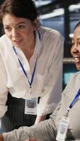 Vertical Cheerful data center technicians satisfied with results after collaborating on AI automation deployment. Happy server hub coworkers adjust machine learning configurations, working together, camera A video