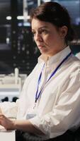 Vertical Data center technician monitors server rigs performing AI training and inference tasks. Server hub IT professional oversees high tech systems managing deep learning storage operations, camera A video