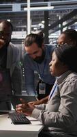 Vertical Angry technicians in server room fighting each other after encountering critical error popup during maintenance. Engineers having tense conversation, doing system recovery brainstorming chat, camera A video