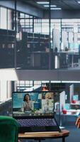 Vertical Professional team using call technology to support company development and decision making, reinforcing workplace cooperation and discussing with associates for growth. Camera B. video