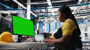Solar panels plant engineer overseeing energy consumption using isolated screen PC. Photovoltaics facility employee ensuring optimal use of manufacturing resources using monitor. Camera B. video