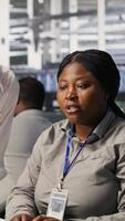 Vertical Data center team leader and IT expert reviewing performance dashboards of AI equipment rigs. Server room manager oversee system administrator examining machine learning algorithms on screen, camera A video