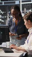 Vertical Cheerful data center engineers doing fist bump after completing successful AI system deployment. Smiling coworkers celebrating after achieving optimal machine learning model performance, camera A video