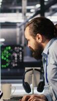 Vertical Anxious technicians in data center reacting to system lockdown caused by ransomware alert. IT professionals under pressure evaluating security breaches and scrambling to contain damage, camera A video