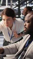 Vertical Lead data center admin overseeing IT expert integrating AI in equipment rigs. African american employee under server farm team leader supervision using deep learning for operational tasks, camera A video