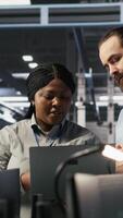Vertical Data center engineering team colleagues collaborating on blade servers maintenance to ensure continuous AI processing. Technicians manage infrastructure supporting machine learning pipelines, camera A video