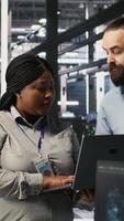 Vertical Data center engineers performing maintenance on blade server units used for artificial intelligence processing. IT professionals manage data center arrays used for machine learning training, camera A video
