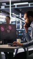 Vertical Engineer in data center frustrated by critical error popup on monitor during diagnostics session. IT expert stressed while troubleshooting system fault affecting infrastructure performance, camera A video