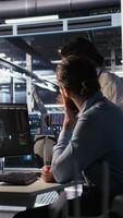 Vertical Programmers doing brainstorming in server room, reviewing neural network code and LLM visualization dashboards. Data center coworkers monitoring artificial intelligence systems performance, camera A video