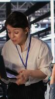 Vertical Data center admins working together, collaborating on neural network software development. Teamworking server hub colleagues implementing artificial intelligence technology in workplace, camera A video