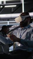 Vertical Data center developer using virtual reality technology to visualize artificial intelligence LLM neural networks. Server farm IT expert using VR headset equipment to oversee AI systems, camera A video