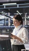 Vertical Data center team leader supervising system operations supporting neural networks and analytics workflows. Server hub manager monitoring engineering team managing AI training datasets, camera A video