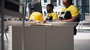 African American engineer offers service from solar panel call center, managing help line requests for support and maintenance. Customer support operator improve factory operations. Camera B. video