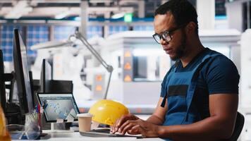 Solar energy expert updates design models in eco friendly factory with a focus on research and innovation. Male worker supports sustainable industrial growth using digital systems. Camera A. video