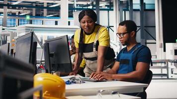 Engineers monitor solar system software at desk in modern factory, team of specialists overseeing energy production and configures equipment in a high tech photovoltaic facility. Camera B. video