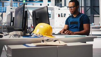 Solar energy expert updates design models in eco friendly factory with a focus on research and innovation. Male worker supports sustainable industrial growth using digital systems. Camera B. video