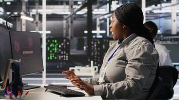 Panicked system administrator in data center reacting to spyware warning on PC screen, launching emergency response protocol. Worker trying to repair hacked equipment systems, camera A video