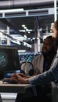 Vertical Lead data center engineer oversees team integrating AI automation tools during infrastructure maintenance. Worker under manager supervision uses machine learning models for operational tasks, camera A video
