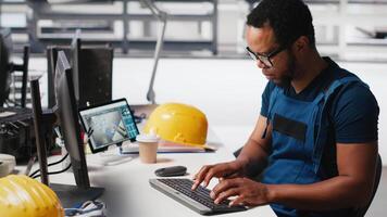 Engineer investigating malfunctioning systems in photovoltaics factory, comparing parameters with pc and tablet. Black man inspecting solar panels manufacturing plant, high tech. Camera A. video