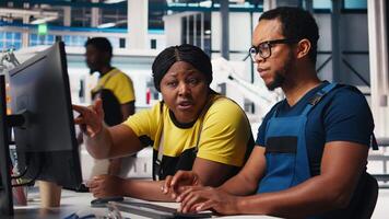 Employees work on photovoltaic design updates in clean energy plant, reducing downtime for operational efficiency in a solar panel factory. Black team of engineers fixing technical issues. Camera B. video
